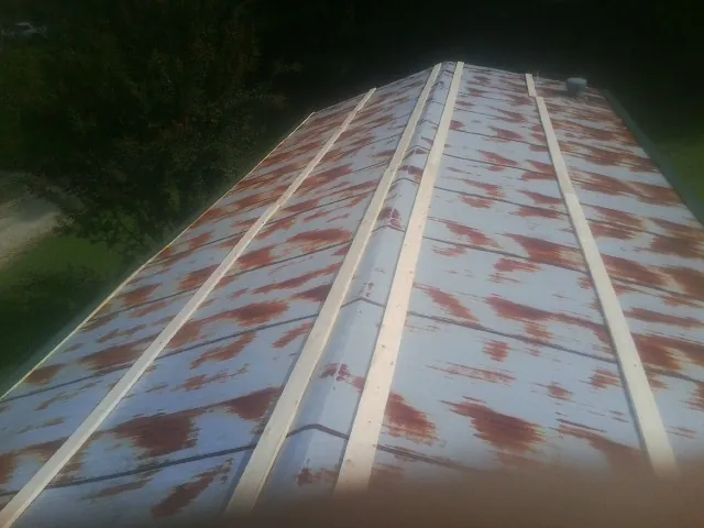 Rusted metal roof panels with new wood purlins before replacement — Storm Damage Roof Repair in Farmville by Roofing Brothers