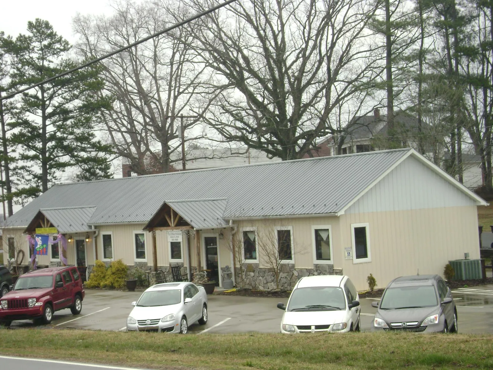 Gray metal roof with timber entry brackets on a small commercial building in Farmville